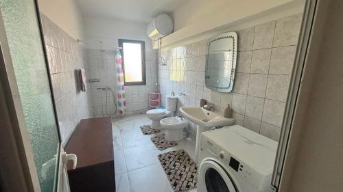 ein Badezimmer mit Waschbecken, Toilette und Waschmaschine in der Unterkunft Lin Luli in (( Shën Ded Gjoni ))