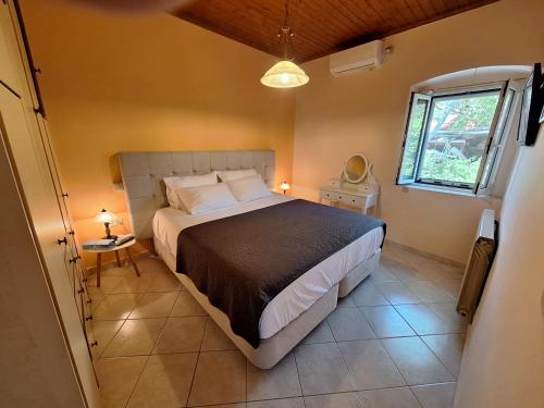 a bedroom with a large bed and a window at Casa di TSANES in Pinakokhórion
