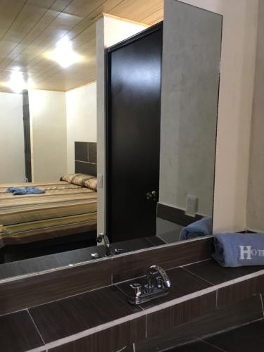 um espelho de casa de banho com um lavatório e uma cama em 8 Hotel Ejecutivo em Jocotitlán