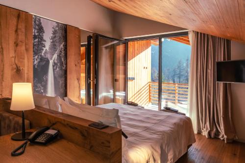 a bedroom with a bed and a phone and a window at Silou Retreat in Champdepraz