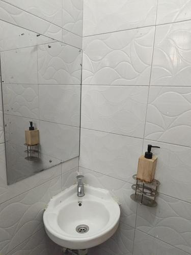 a white bathroom with a sink and a mirror at Gweth Haven Homes in Nakuru
