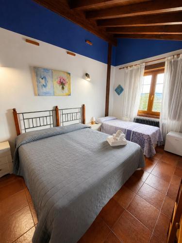 two beds in a bedroom with blue walls at Posada El Valle - Adults Only in Suances