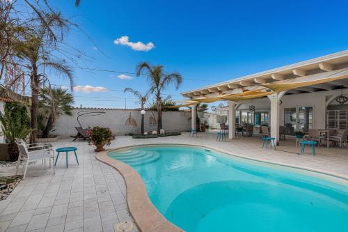 a swimming pool with a patio and a house at Marechiaro Pool & Restaurant in Paestum