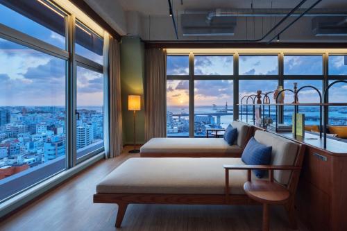 a hotel room with two beds and a large window at South Gate Hotel Okinawa Naha Tomari Port - Direct Access to Tomarin in Naha