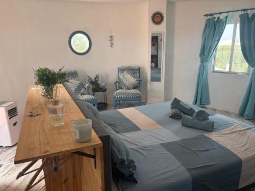 a bedroom with a large bed with a wooden table at Casa El Flamenco Zoutmeer Torrevieja 6 of 8 personen in Torrevieja