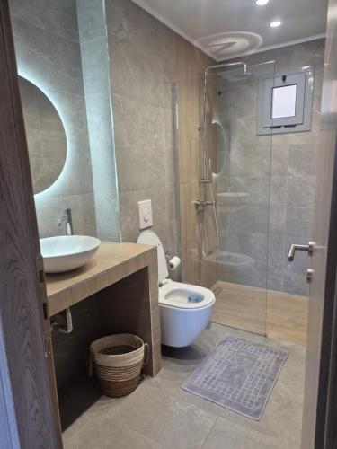 a bathroom with a toilet and a sink and a shower at Celivine Seaside Residence in Faliraki