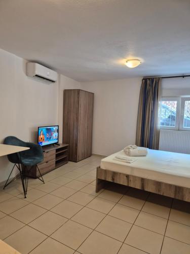 a bedroom with a bed and a tv and a desk at Blue studio in Kavála