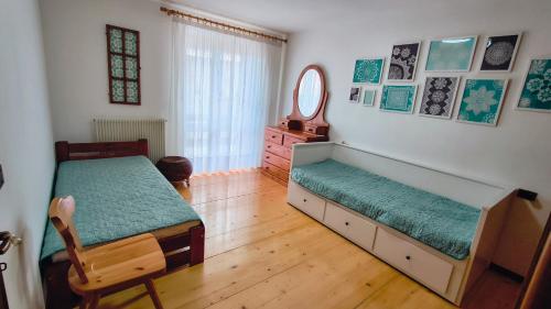 a bedroom with two beds and a mirror at Casa Pal Piccolo - Apartment with garage for bikes and fast wifi in Paluzza