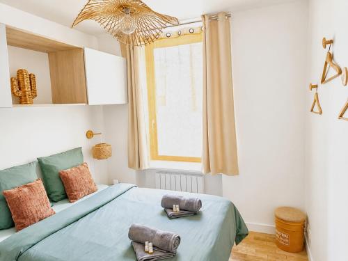a bedroom with a bed with two towels on it at Le Byzantin - T2 Hyper centre in Pontivy