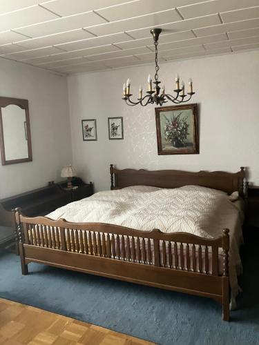 a bedroom with a large bed and a chandelier at Haus Eichholz in Tellingstedt