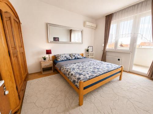 a bedroom with a bed and a large window at Abrazo in Orašje