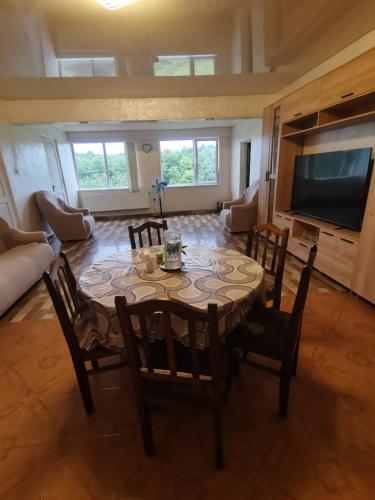 a dining room with a table and chairs and a television at Фазенда Оганеса in Ureki