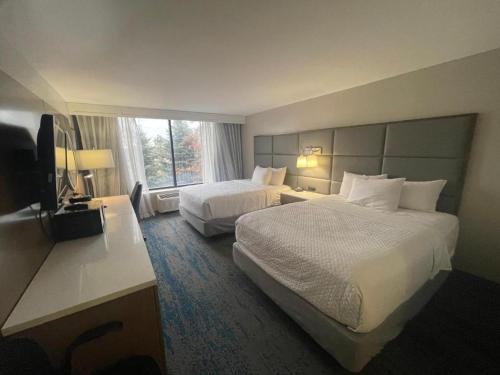 a hotel room with two beds and a flat screen tv at FairBridge Inn & Suites Independence in Cleveland