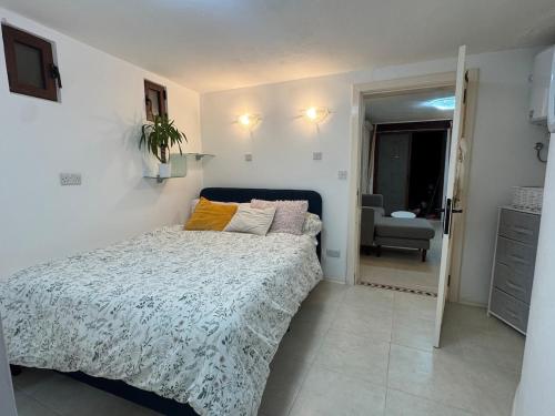 a small bedroom with a bed and a chair at Tranquil garden hideaway in Gozo in San Lawrenz