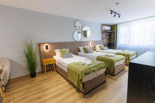 a hotel room with two beds and a mirror at Boulevard Hotel in Aytos