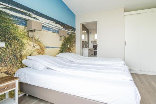 a bedroom with a bed with a beach mural on the wall at Buitenplaats Oudendijke in Ellemeet