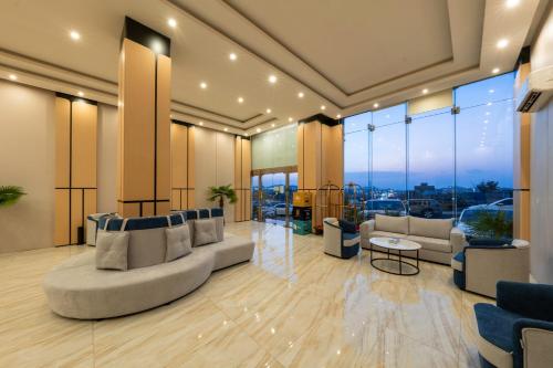 a living room with couches and tables and windows at القصر الإسكان in Khamis Mushayt