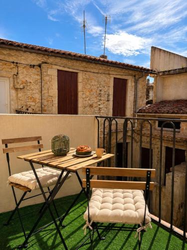 a table and two chairs sitting on a balcony at Terrasse - CLIM - Arènes à pied - 4 pers in Nîmes