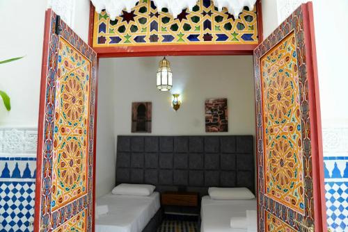 an open door into a room with two beds at Riad Chouara in Fez