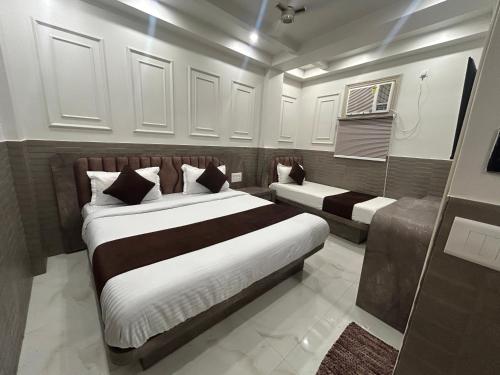 a bedroom with two beds and a air conditioner at Grand Tree Hotel Shree Guru in New Delhi