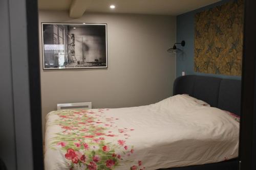 a bedroom with a bed with flowers on it at Verborgen Pareltje in Bray-Dunes