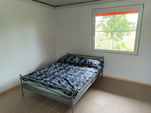 a bed in a room with a window at Śródziemie Erebor in Leśno