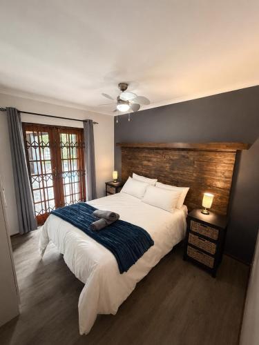 a bedroom with a large bed with a stuffed animal on it at Tivoli House in Edgemead