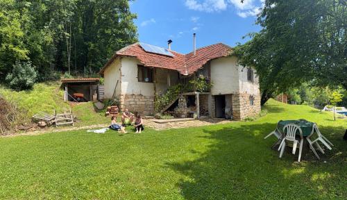 a group of people sitting in the yard of a house at Malajac Bigrenica in Bigrenica