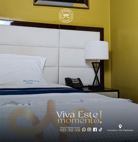 a bedroom with a bed and a lamp and a phone at Hotel DPanda House in Cacuaco
