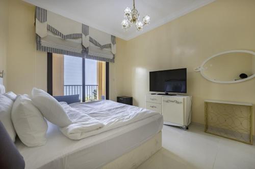 a bedroom with a large bed and a television at Bloomfields 2BR+Maid in Mina Fajer - Fujairah in Fujairah