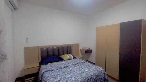 a bedroom with a bed with a blue comforter at Maison d'hôtes Jaxaay in Keur Massar