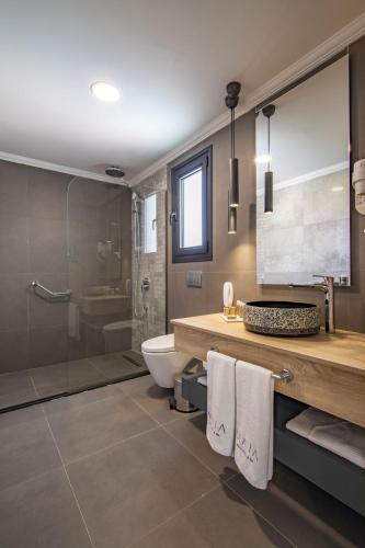 a bathroom with a sink and a toilet and a shower at MAIA Luxury Beach Hotel & Spa in Güzelçamlı