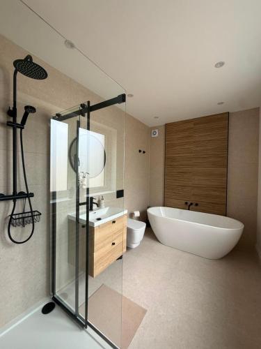 a bathroom with a tub and a toilet and a sink at Cour Cottage in Drem