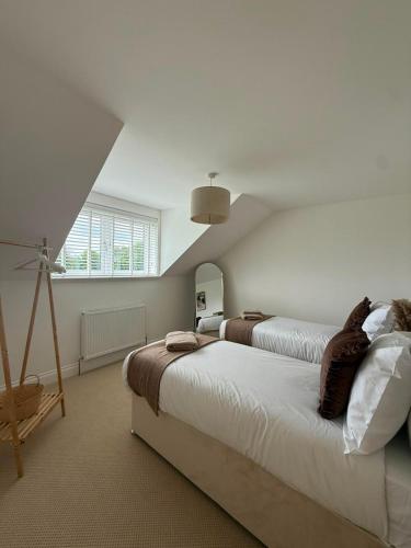 a bedroom with two beds with cats sitting on them at Cour Cottage in Drem