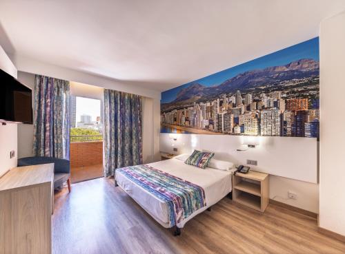 a hotel room with a bed and a view of a city at Hotel Tropic in Cala de Finestrat