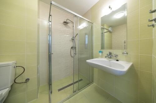 a bathroom with a sink and a glass shower at Penzión Bergmannhof in Ladomer
