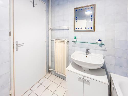 a white bathroom with a sink and a mirror at La Parenthèse Loggia - Calme & proche Disney in Champigny-sur-Marne