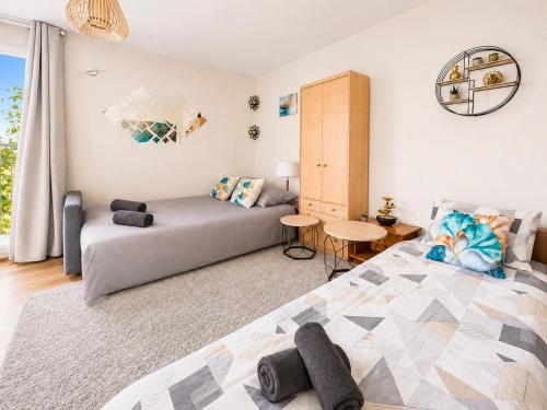 a living room with a bed and a table at La Parenthèse Loggia - Calme & proche Disney in Champigny-sur-Marne