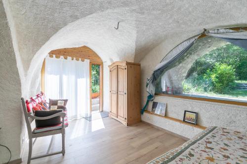 a room with a large window and a chair at Les Rochas - Duplex pour 7 personnes in Champcella