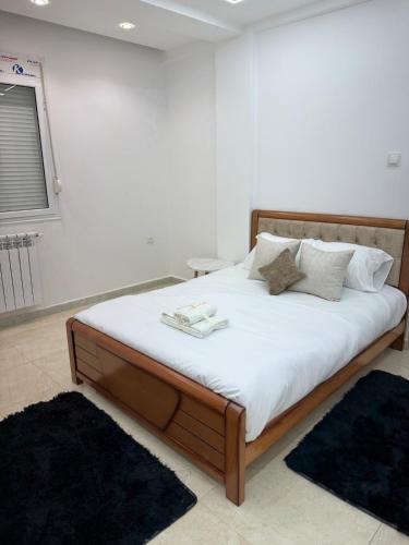 a bedroom with a large bed with white sheets and pillows at Appartement El-Chahed in Annaba