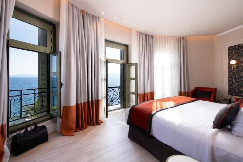 a hotel room with a bed and large windows at Thermae Sylla Spa & Wellness Hotel in Loutra Edipsou