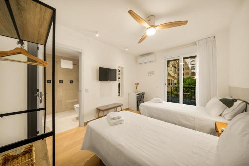 a hotel room with two beds and a bathroom at Jomarijo Boutique Rooms in Fuengirola