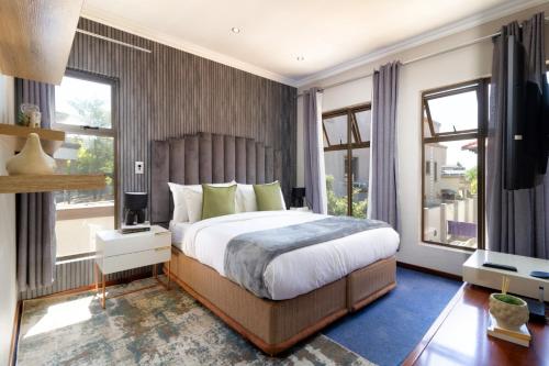 a bedroom with a large bed and two windows at Alimama Spaces: Manson Mansion in Randjesfontein