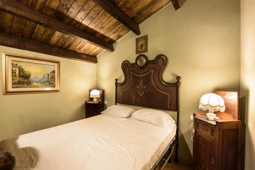 a bedroom with a large bed with a wooden headboard at Villa Fozzi in Bonorva
