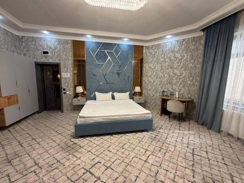 a bedroom with a bed and a blue wall at Royal Hotel Navoi in Navoi