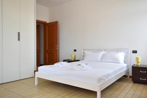 a bedroom with a white bed with two towels on it at Welc-ōM Conselve Matteotti in Conselve