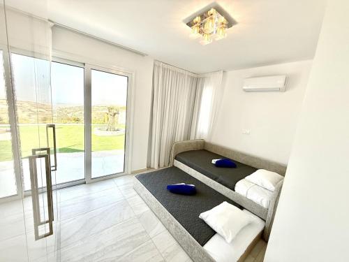 a bedroom with two beds and a large window at Seaview Panorama Villa in Drousha