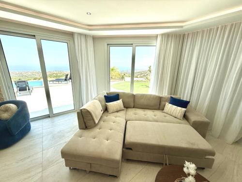 a living room with a couch and a large window at Seaview Panorama Villa in Drousha