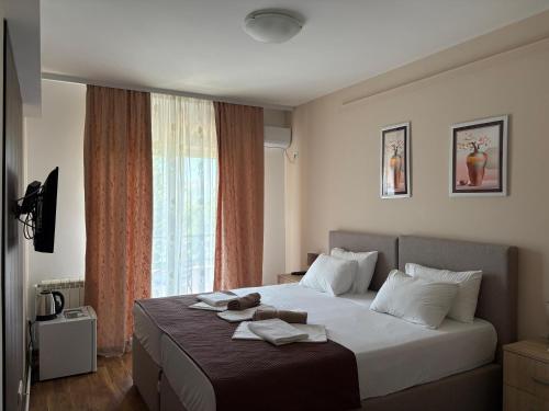 a bedroom with a large bed with towels on it at Guesthouse P&A in Budva