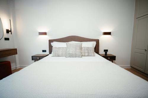 a bedroom with a large white bed with two lamps at Aida's Apartment Nafplio in Nafplio